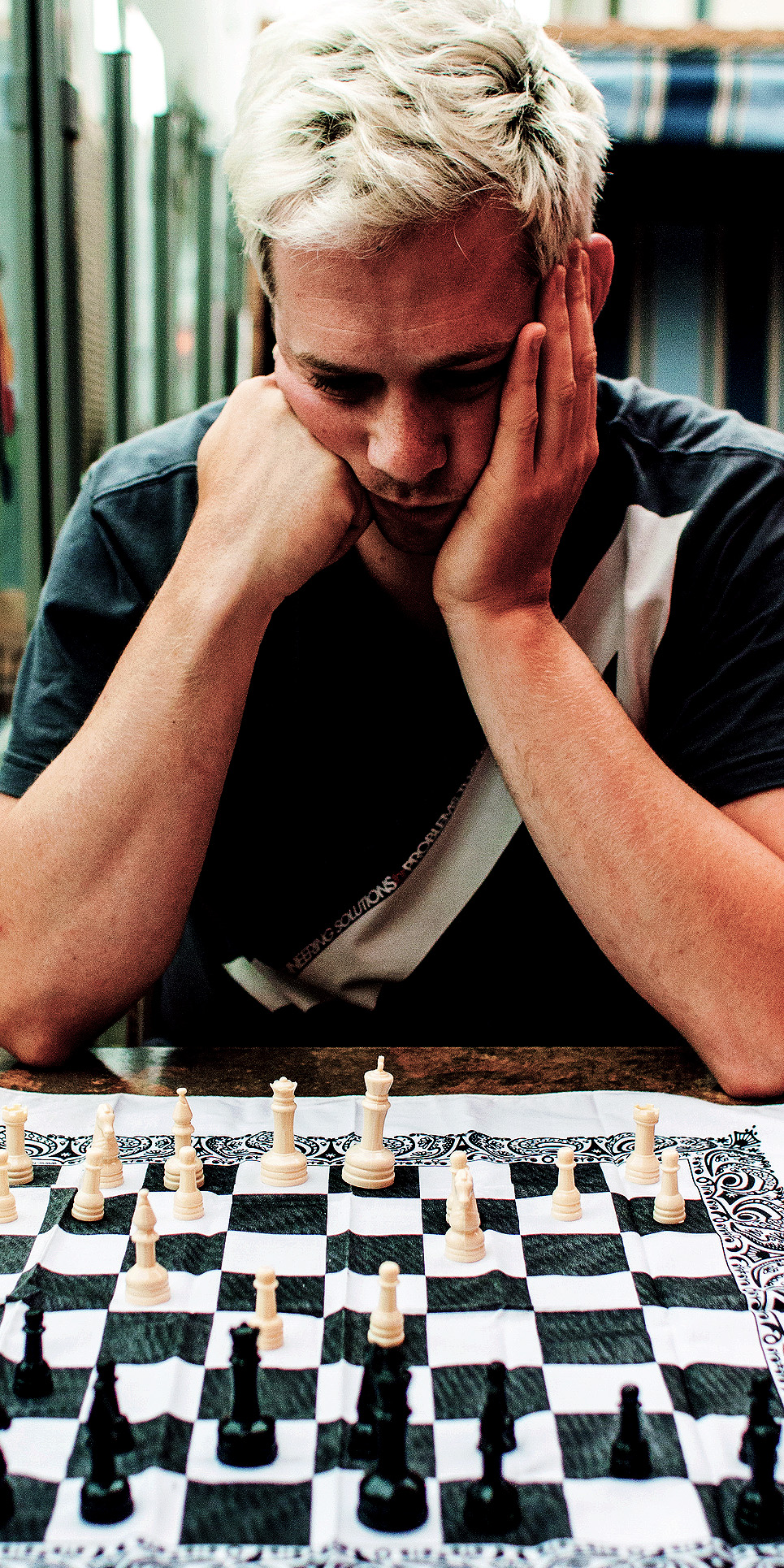 Man contemplating a chess board.